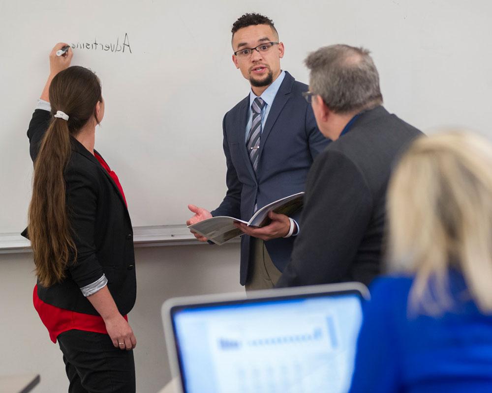 Students writing on the white board in class